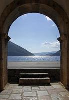 vista de la bahía de kotor, montenegro, desde la entrada de un edificio arqueado en perast. foto