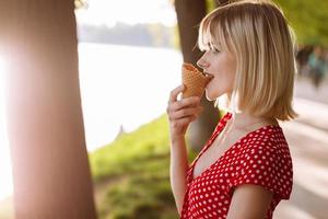 girl with short hair. beautiful young cheerful happy girl eating ice cream smiling in sunny day photo