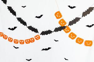 Trick or Treat concept. Holiday composition with halloween garland decorations pumpkins and bats isolated on white background. Preparation for Halloween party. Autumn fall happy Halloween photo