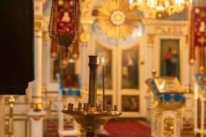 Iglesia Ortodoxa. cristiandad. decoración interior festiva con velas encendidas e icono en la iglesia ortodoxa tradicional en vísperas de pascua o navidad. religión fe orar símbolo. foto