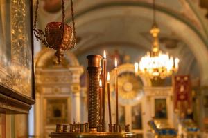 Iglesia Ortodoxa. cristiandad. decoración interior festiva con velas encendidas e icono en la iglesia ortodoxa tradicional en vísperas de pascua o navidad. religión fe orar símbolo. foto