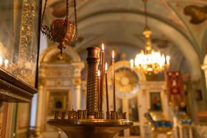 Iglesia Ortodoxa. cristiandad. decoración interior festiva con velas encendidas e icono en la iglesia ortodoxa tradicional en vísperas de pascua o navidad. religión fe orar símbolo. foto