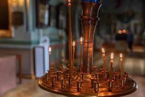 Iglesia Ortodoxa. cristiandad. decoración interior festiva con velas encendidas e icono en la iglesia ortodoxa tradicional en vísperas de pascua o navidad. religión fe orar símbolo. foto