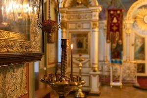 Iglesia Ortodoxa. cristiandad. decoración interior festiva con velas encendidas e icono en la iglesia ortodoxa tradicional en vísperas de pascua o navidad. religión fe orar símbolo. foto