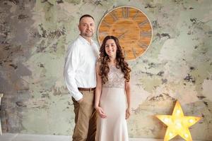 Photo shoot in the studio of a young married couple. A guy with a girl in festive clothes are celebrating Christmas. New Year's love story. The New Year Concept. valentine's day