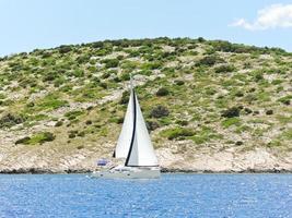 white yacht sailing near Dalmatia coast photo