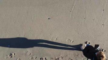 femme adulte marche sur le sable d'une plage dans l'ouest de la ligurie un dimanche d'hiver