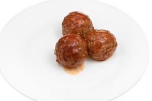 meatballs under meat sauce on plate photo