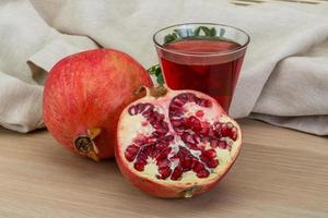 Pomecranet juice on wooden background photo