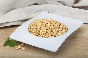 Cedar nut in a bowl on wooden background photo