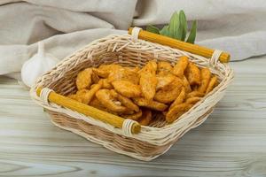 Croutons in a basket on wooden background photo