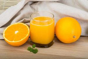 Orange juice on wooden background photo