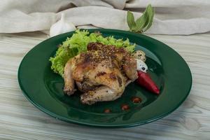 Quail grilled on the plate and wooden background photo