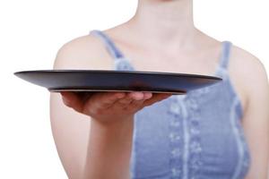 la mujer sostiene un plato negro vacío en la mano foto