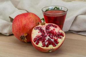 Pomecranet juice on wooden background photo