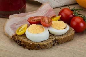 Bacon sandwich on wooden background photo