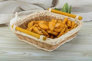 Croutons in a basket on wooden background photo