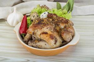 Quail grilled in a bowl on wooden background photo