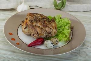 Quail grilled on the plate and wooden background photo