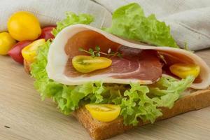 Sandwich with hamon on wooden background photo