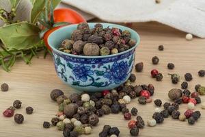 Pepper mix in a bowl on wooden background photo