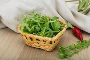 Ruccola in a basket on wooden background photo