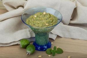 Feijoa jam in a bowl on wooden background photo