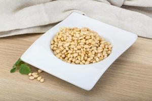 Cedar nut in a bowl on wooden background photo