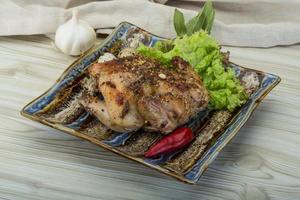 codorniz a la parrilla en el plato y fondo de madera foto