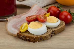 Bacon sandwich on wooden background photo