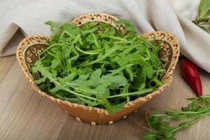 Ruccola in a basket on wooden background photo