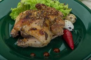 Quail grilled on the plate and wooden background photo