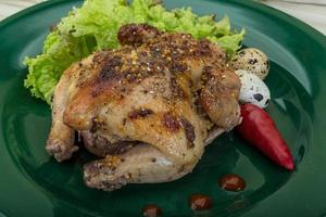 Quail grilled on the plate and wooden background photo