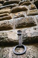 ring of hitching post on wall of medieval house photo