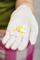 several pills in gloved hand photo