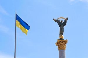 ukrainian flag and Monument to Berehynia in Kiev photo