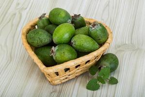 feijoa en una cesta sobre fondo de madera foto