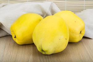 Quince on wooden background photo