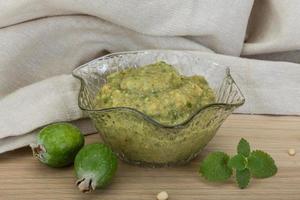 Feijoa jam in a bowl on wooden background photo