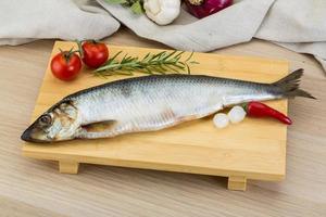 Salted herring on wooden board and wooden background photo