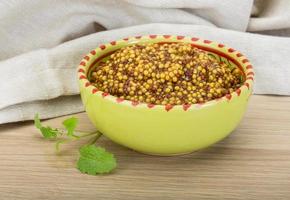 French mustard in a bowl on wooden background photo