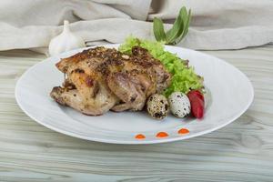 Quail grilled on the plate and wooden background photo