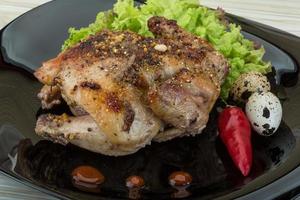 Quail grilled on the plate and wooden background photo