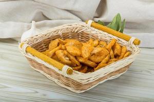 Croutons in a basket on wooden background photo