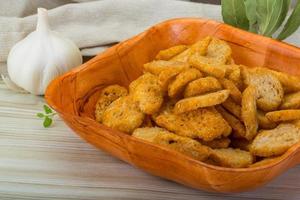 Croutons in a bowl on wooden background photo