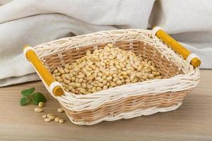 Cedar nut in a basket on wooden background photo