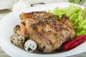 Quail grilled on the plate and wooden background photo