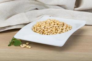 Cedar nut in a bowl on wooden background photo