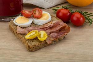 Bacon sandwich on wooden background photo