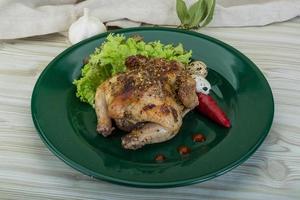 Quail grilled on the plate and wooden background photo